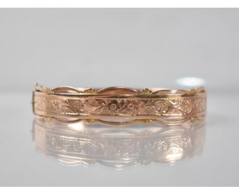 A 9ct Rose Gold Hinged Bangle having Engraved Floral Decoration to Front and Pierced Decoration to Edges, Dated for Birmingha