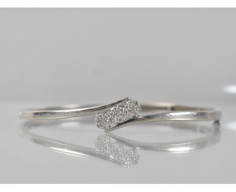 A 9ct White Gold and Diamond Hinged Bangle, Crossed Tapered Shoulders Supporting Trilogy of Diamond Floral Clusters, Each Dia