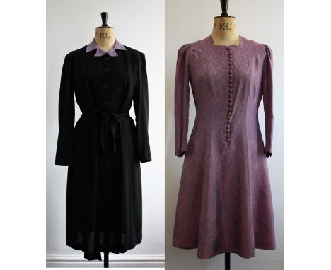 Two vintage 1940s dresses. A black dress with lilac rever collar, button down front, satin-bound pleated top into stitched pl