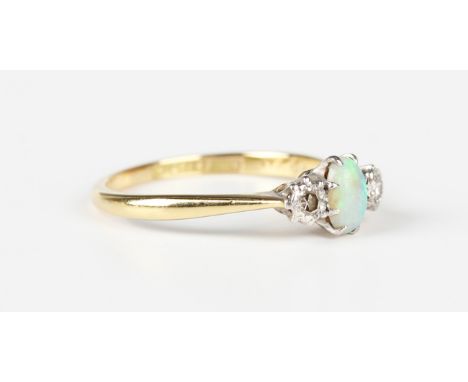 A gold and platinum ring, claw set with an oval opal between two circular cut diamonds, detailed '18ct Pt', weight 2.3g, ring