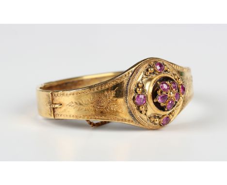 A gold and ruby oval hinged bangle, last quarter of the 19th century, the front mounted with five oval cut rubies within a ci