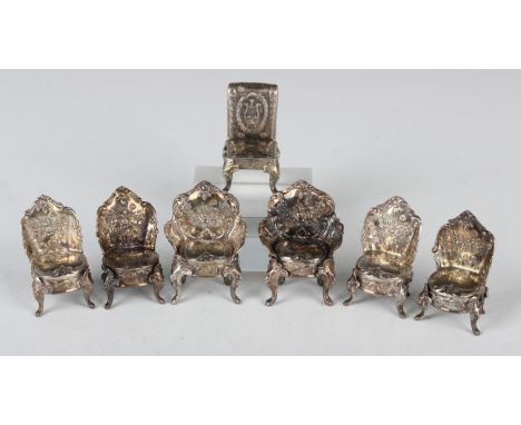 A set of six late Victorian silver toy chairs, each embossed with flowers and scrolls, comprising two salon armchairs and fou