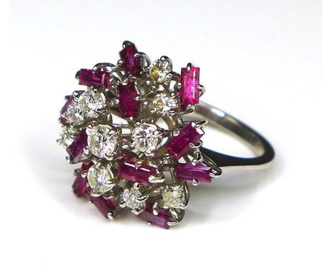 A diamond and ruby dress ring of asymmetrical cluster form, set in white gold or platinum, composed of ten brilliant cut diam