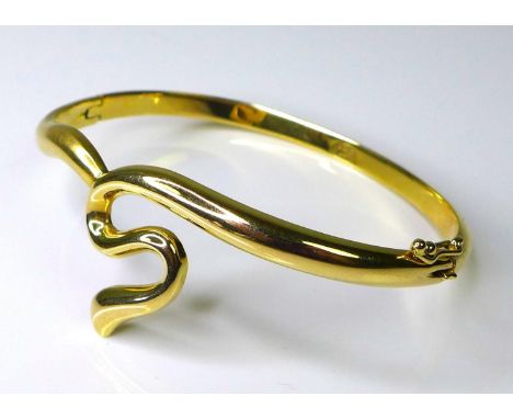 A 14ct gold bangle of sinuous design, with hinged clasp, 19.3g. 