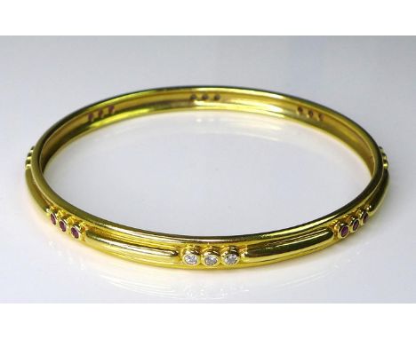 A Garrard 18ct gold, diamond and ruby bangle, banded design set with groups of three diamonds followed by three rubies, twelv