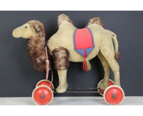 Early to Mid 20th century Steiff mohair camel on wheels, straw filled, glass eyes, standing on a metal bar frame with red pai