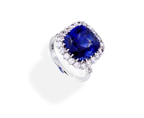 SAPPHIRE AND DIAMOND CLUSTER RINGSet with a cushion-shaped sapphire, within a brilliant-cut diamond surround,  diamonds appro