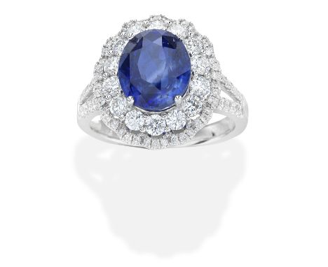 SAPPHIRE AND DIAMOND CLUSTER RINGThe 3.58 carat oval-cut sapphire and brilliant-cut diamonds, diamonds approx. 0.95ct total, 