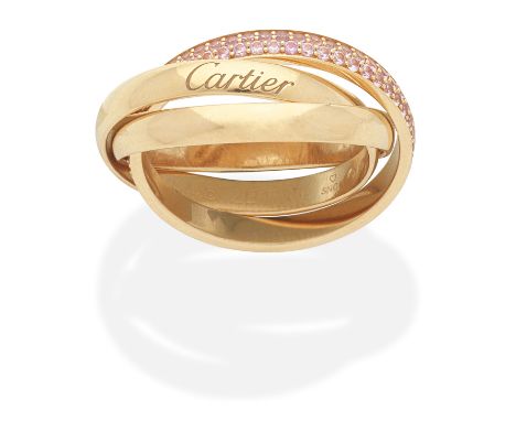 CARTIER: PINK SAPPHIRE TRINITY RINGOne band pavé-set with circular-cut pink sapphires, mounted in 18 carat rose gold, signed 