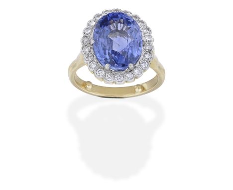 SAPPHIRE AND DIAMOND CLUSTER RINGThe oval-cut sapphire, weighing 9.45 carats, within a brilliant-cut diamond surround, ring s