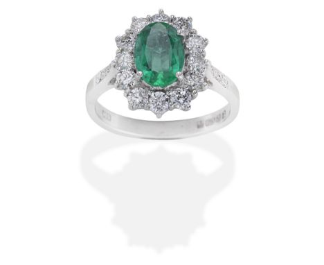 EMERALD AND DIAMOND CLUSTER RINGThe oval-cut emerald within a brilliant-cut diamond surround and shoulders, emerald approx. 1