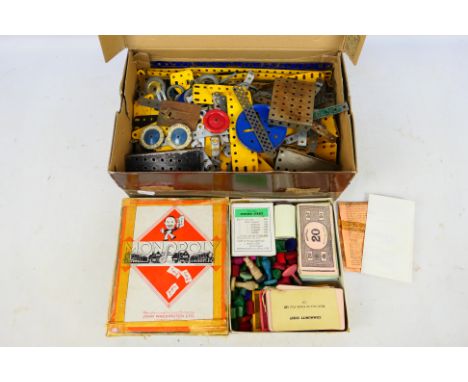 Meccano - Monopoly - A collection of vintage Meccano pieces including wheels and pulleys and a 1940s Monopoly set but no boar