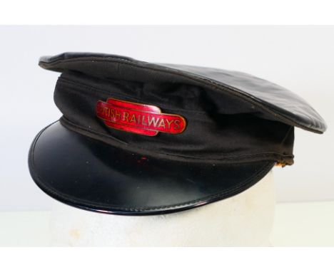 A British Rail peaked cap with applied British Railways enamel badge, size 6¾ and dated 1963. [W]