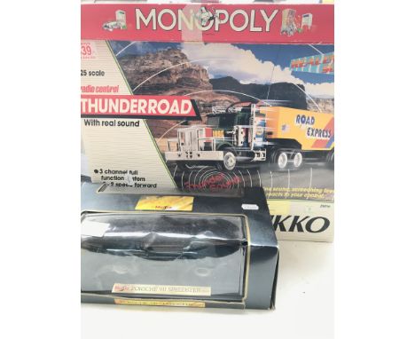 A Boxed Nikko Radio Controlled Thunder Road Lorry 1/25 Scale. A Monopoly Board Game and a Maisto Porsche 911.