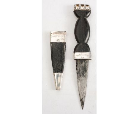 A George VI silver mounted skean dhu by Robert G Lawrie Ltd, Glasgow, 1949:, with short blade over a silver hilt, carved bog 