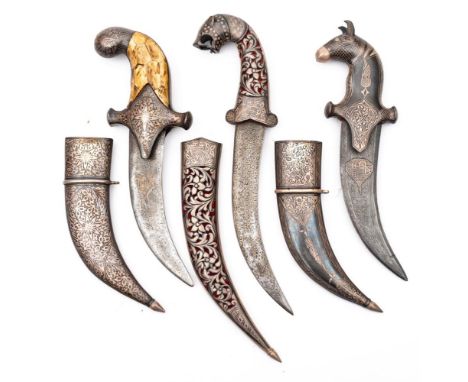 A group of three jambiyas:, two with short signed damascus blades with niellowork grips and scabbards, the third with unsigne