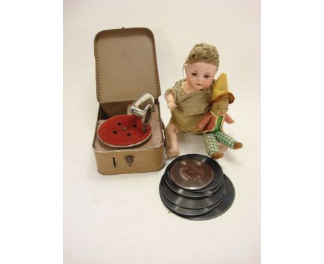 A child's tinplate rexine cased gramophone:, together with a group of records, a Norah Wellings style doll and a bisque head 