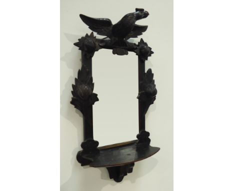 Late 19th century wall mirror with shelf, ebonised frame carved with bird, flower heads and foliage, 79cm x 44cm Condition Re