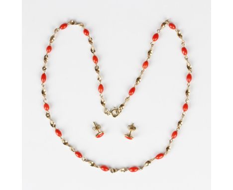 A gold and coral necklace in a twist link design with oval coral beads mounted at intervals, on a boltring clasp, detailed '5