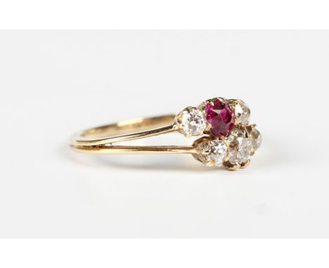 A gold, ruby and diamond ring of split shank two row design, claw set with a cushion cut ruby, a principal cushion cut diamon