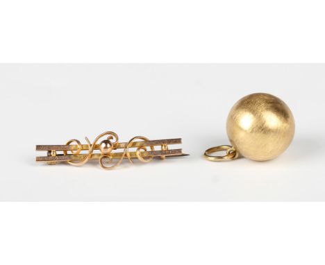 A gold bar brooch, detailed '9ct', weight 1.9g, width 3.8cm, and a gold spherical pendant, the suspension ring detailed '750'