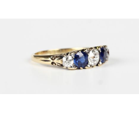 A gold, sapphire and diamond ring, early 20th century, mounted with three cushion cut diamonds alternating with two cushion c