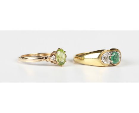 A gold ring, claw set with an oval cut emerald between circular cut diamond set two stone shoulders, detailed '750', weight 4