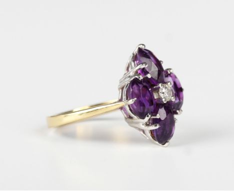 An 18ct gold ring, claw set with a circular cut diamond within a surround of four oval cut amethysts, London 1973, weight 3.8