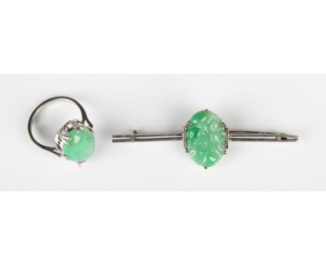 A jade single stone ring, claw set with an oval jade cabochon, ring size approx J1/2, and a jade bar brooch, claw set with an