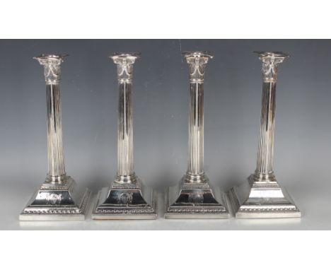 A set of four George III silver Corinthian column candlesticks, each with a beaded detachable nozzle above a swagged sconce a