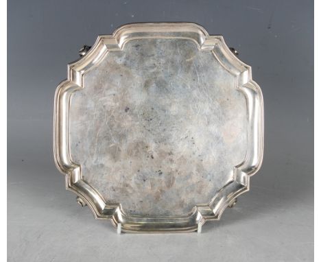 A George V silver shaped square card salver on scroll feet, London 1929 by Goldsmiths &amp; Silversmiths Co Ltd, weight 378.6