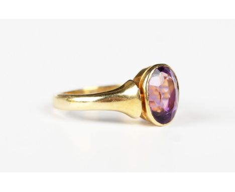 A gold ring, collet set with an oval cut amethyst, indistinct mark, weight 3.7g, ring size approx M, with a case.Buyer’s Prem