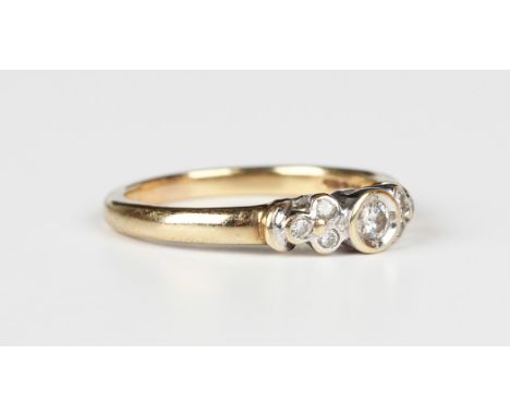 A 9ct gold and diamond ring, mounted with the principal circular cut diamond between circular cut diamond set trefoil shaped 