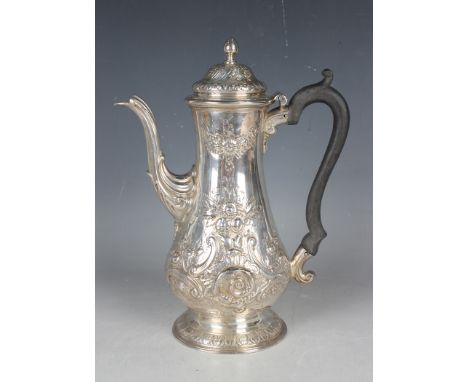 A George III silver baluster coffee pot with floral and foliate embossed decoration framing a vacant 'C' scroll cartouche, on