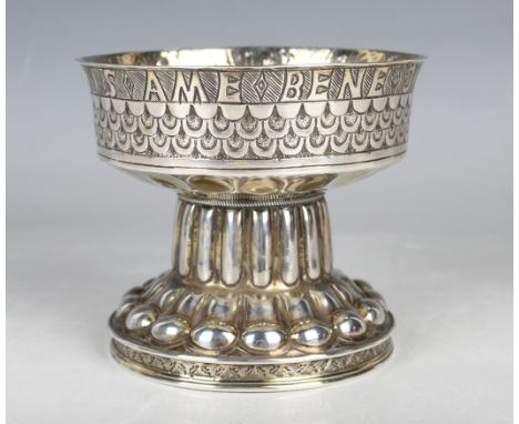 An Edwardian silver gilt replica of the Tudor Cup, the font shaped cup with Latin inscription above scale decoration, on a re