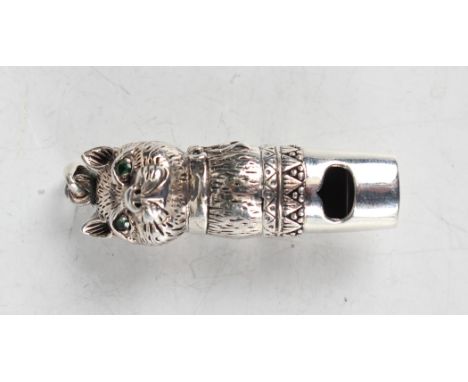 A sterling silver novelty whistle in the form of a cat's head with green coloured paste eyes, fitted with a suspension loop, 