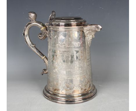 A Victorian silver flagon with hinged lid above a tapering cylindrical body, engraved with opposing Bacchanalian scenes of pu