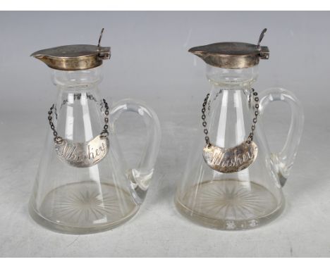 A pair of Edwardian silver mounted clear glass whisky tots, each of conical form with silver collar and tappit hinged lid, Bi