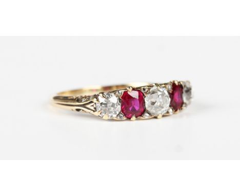 A gold, ruby and diamond ring, early 20th century, mounted with three cushion cut diamonds alternating with two oval cut rubi