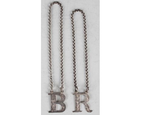 A near pair of Victorian silver decanter labels in the form of the letters 'R and B', each engraved with floral decoration, B