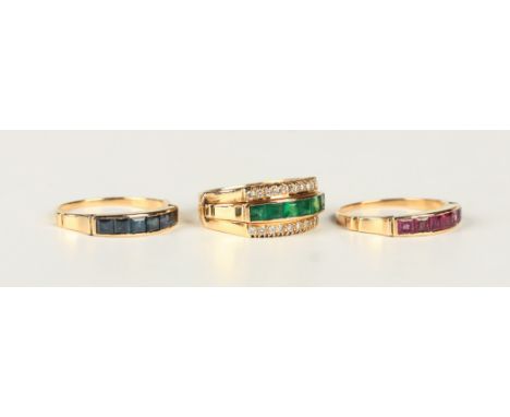 A gold ring with three interchangeable central bands, mounted with sapphires to one, rubies to the second and emeralds to the