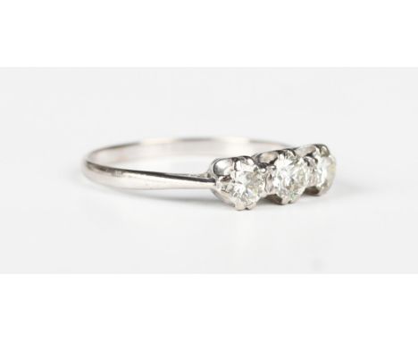 A diamond three stone ring, claw set with a row of circular cut diamonds, unmarked, ring size approx U1/2.Buyer’s Premium 29.