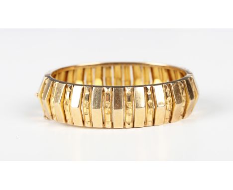 A gold oval hinged bangle with faceted decoration, on a snap clasp, detailed  '22', weight 39.9g, inside width 5cm.Buyer’s Pr