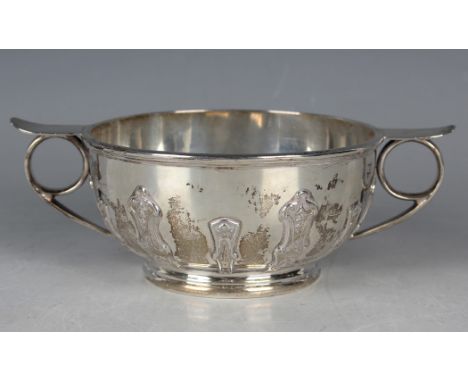 A George V silver circular bowl, cast with strapwork decoration, flanked by ring and tab handles, Birmingham 1926 by George U