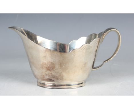 An Elizabeth II silver sauceboat with wavy rim and scroll handle, on an oval foot, Sheffield 1962 by Mappin &amp; Webb, weigh