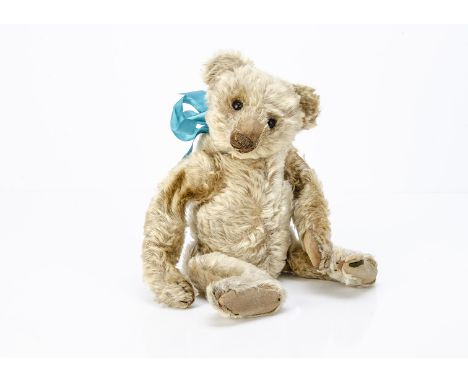 An early Steiff teddy bear circa 1910,  with blonde mohair, black boot button eyes, pronounced clipped muzzle, black stitched