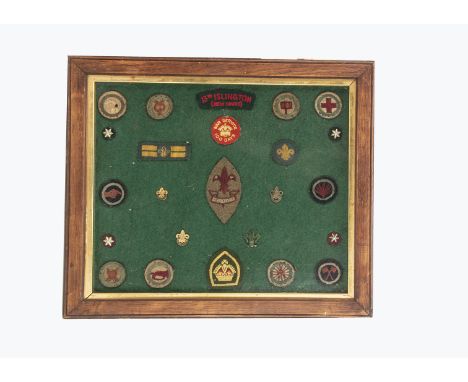 A mounted group of Boy Scout 13th Islington (New Court) badges,  three gilt Boy Scout pins, a green enamel fleur-de-lis badge