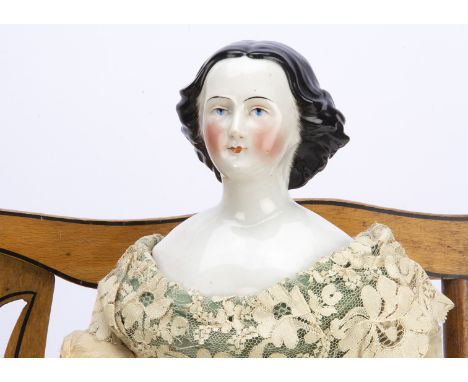 A mid 19th century china shouder-head lady doll,  possibly Hass of Schlaggenwald with blue painted eyes, red eyelid line, red