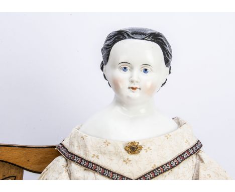 An early German china shoulder head girl doll, with blue painted upward glancing eyes, red eyelid line, feint eyelashes, deli