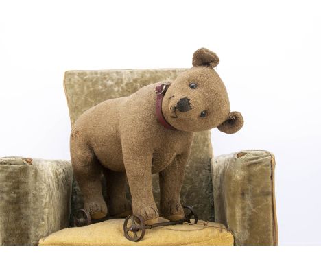 An early Steiff brown burlap bear on wheels,  with black boot button eyes, pronounced muzzle with black stitched nose, mouth 